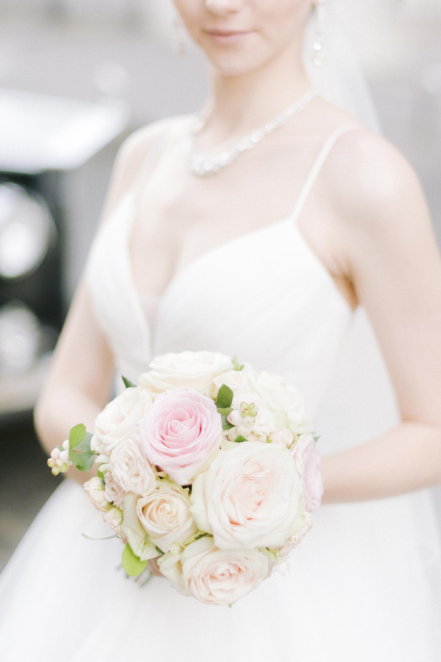 un petit boquet rond que porte la mariée